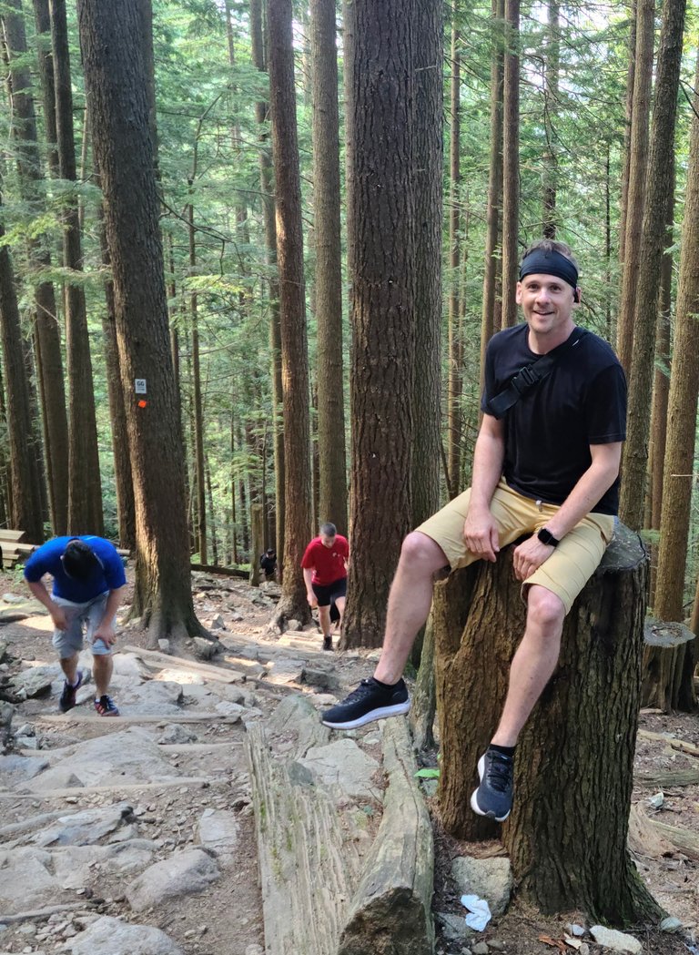 grouse grind sitting on tree stump.jpeg