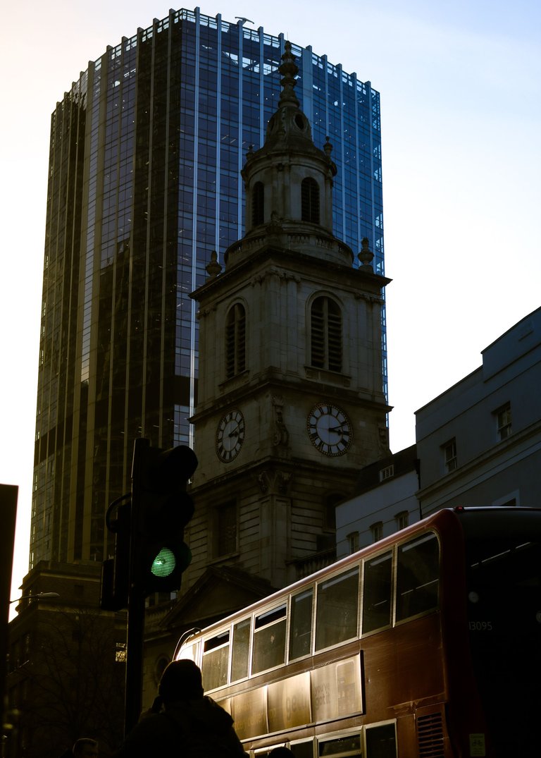 clock tower surrounded by buildings and a double decker.jpg