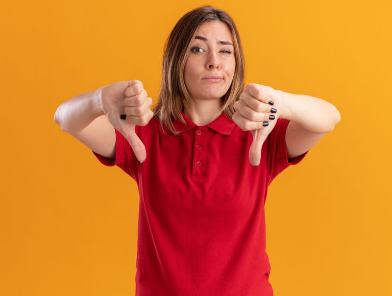 unpleased-young-pretty-woman-thumbs-down-with-two-hands-isolated-orange-wall.jpg