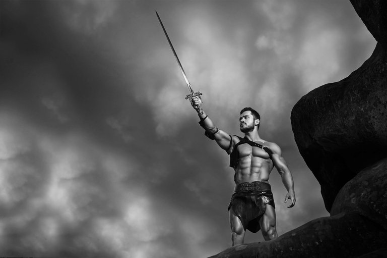 name-god-monochrome-portrait-powerful-muscular-gladiator-holding-his-sword-up-stormy-sky-copyspace.jpg