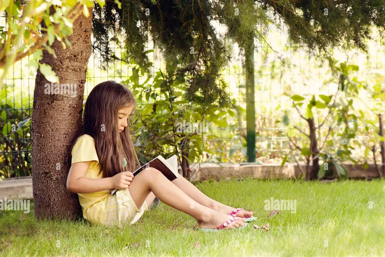 little-girl-reading-book-under-tree-GHK2N7.png