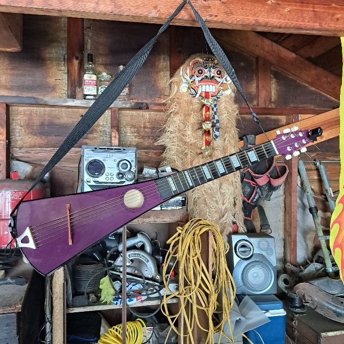 The backpacker guitar hangs in the garage and gets played in the yard.