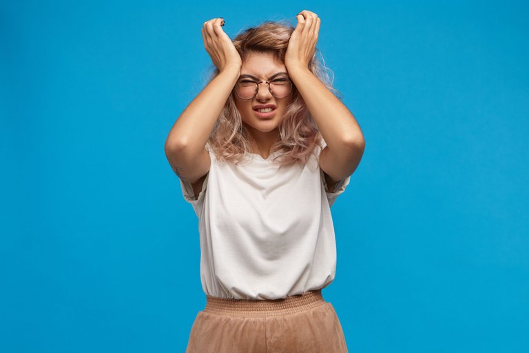 stressed-young-woman-in-stylish-eyewear-squeezing-head-can-t-stand-intolerable-headache-because-of-stressful-day-at-work-annoyed-frustrated-female-grimacing-from-pain.jpg