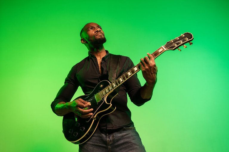 young-african-american-musician-playing-guitar-like-rockstar-gradient-green-yellow-background-concept-music-hobby-festival-open-air-joyful-guy-improvising-singing-song.jpg