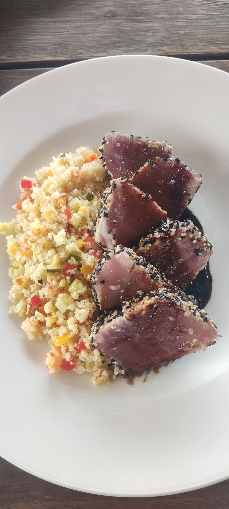 Semi-raw seared tuna in a sesame crust, served with Moroccan couscous with vegetables in olive oil and tarê sauce.