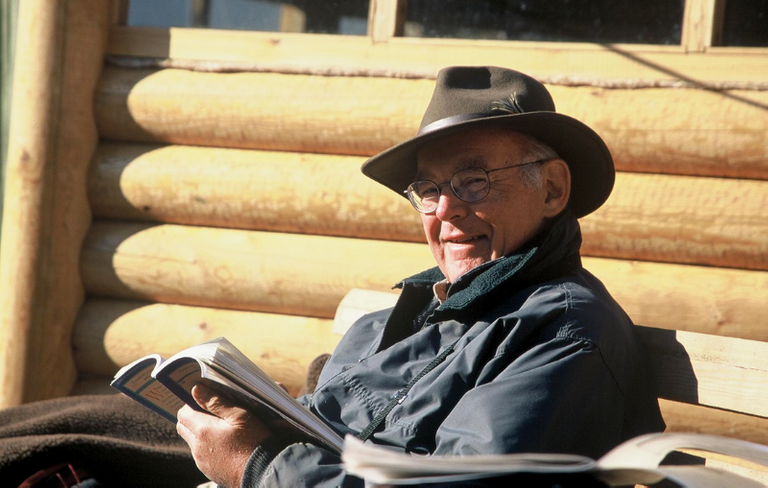 gordon-smiling-with-his-hat-on-reading-a-book.png