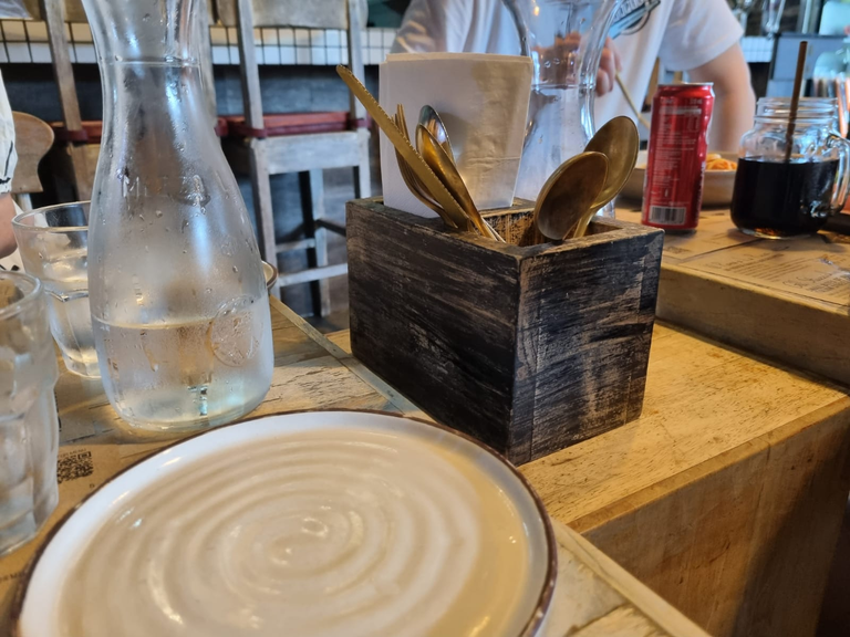 Utensils tucked between the dining table in a wooden holder