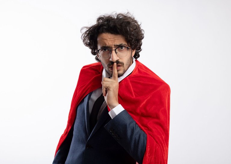 angry-young-superhero-man-optical-glasses-wearing-suit-with-red-cloak-gestures-silence-sign-isolated-white-wall.jpg