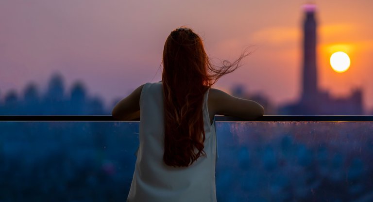 vecteezy_woman-looking-and-enjoying-the-sunset-view-from-balcony-with_8016954.jpg