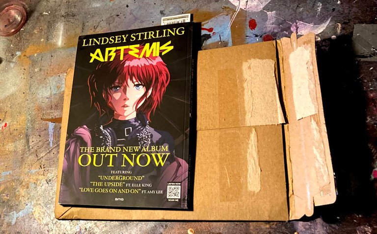The Artemis. graphic novel lying closed with the back cover up on top of the cardboard mailer in which it arrived.