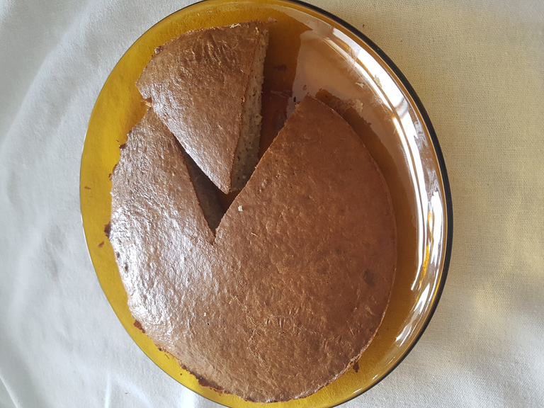 Foto do bolo dentro de um prato, com uma fatia separada ao lado
