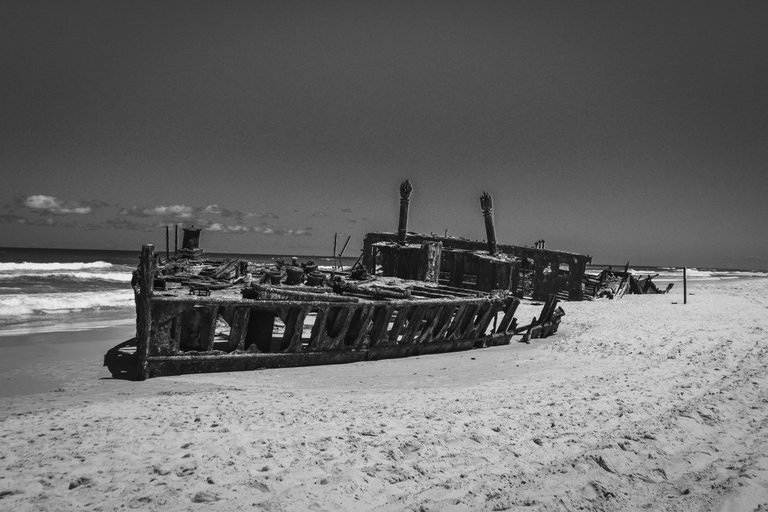 old_wrecked_ship_on_the_sand_by_the_water.jpg