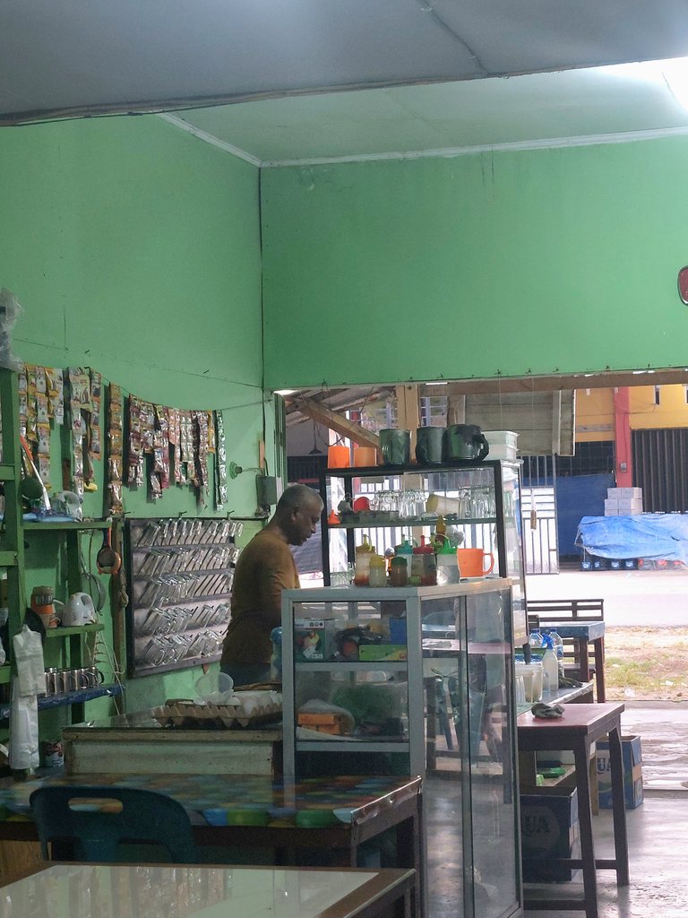Pemilik warung sedang membuat seduhan kopi untuk pengunjung