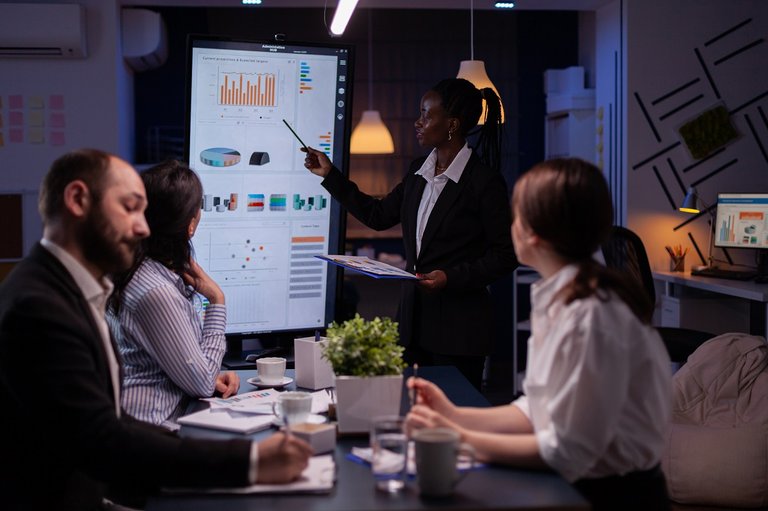 workaholic_african_american_leader_standing_front_presentation_monitor_explaining_marketing_pr.jpg