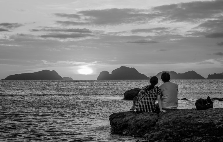 couple_at_dusk_watching_the_sunset_over_the_ocean_1.jpg