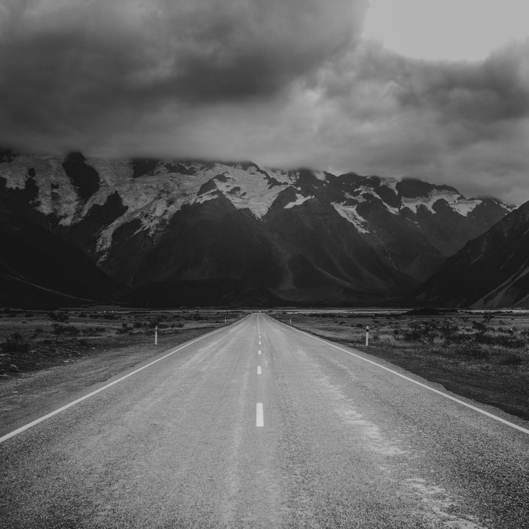 long_and_empty_road_surrounded_by_mountains_2.jpg