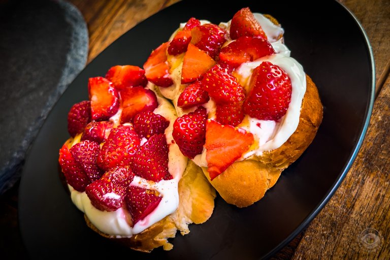 Fresh strawberries on vanilla quark and butter plait garnished with honey and a hint of cinnamon