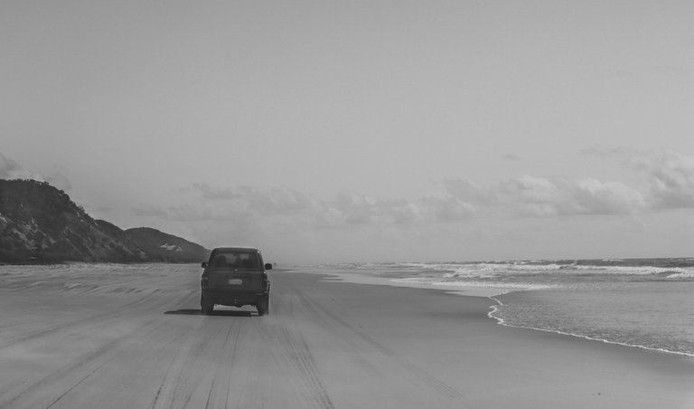 car_driving_on_the_beach_close_to_the_water.jpg