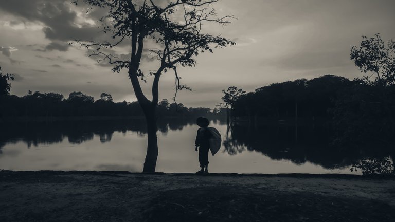 silhouette_of_a_young_kid_with_a_bag_at_sunset_by_the_river_1_2.jpg