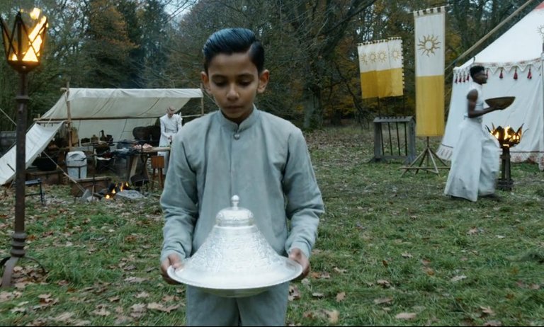 Screenshot of The Wheel of Time Episode 2, depicting a young boy in the camp of the Children of the Light