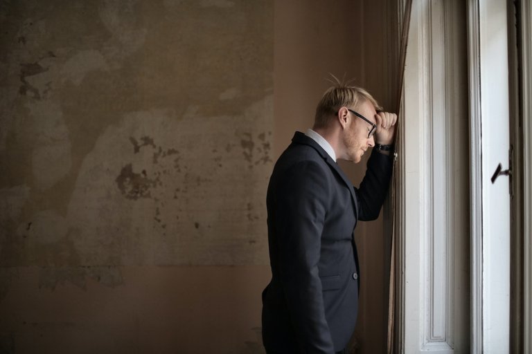 desperate-evicted-male-entrepreneur-standing-near-window-3771129