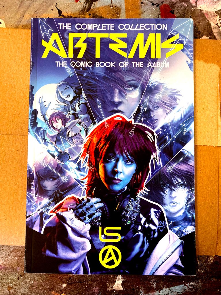 Photo of the front of the Artemis graphic novel, lying on a piece of cardboard on a table