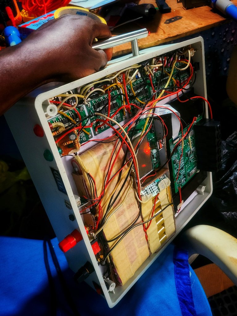 The internals of the X-100 portable power station, showcasing the five battery management system (BMS) circuits, the charge controller, the DC-AC inverter circuit, the microcontroller board and the battery setup.