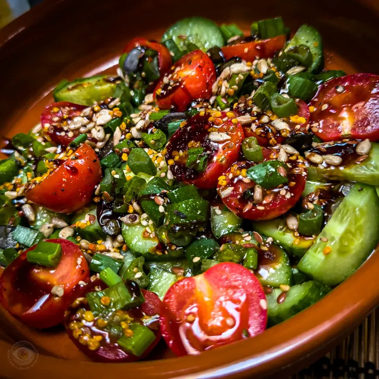 Fresh tomato and cucumber salad with green onions and a handful of oilseeds