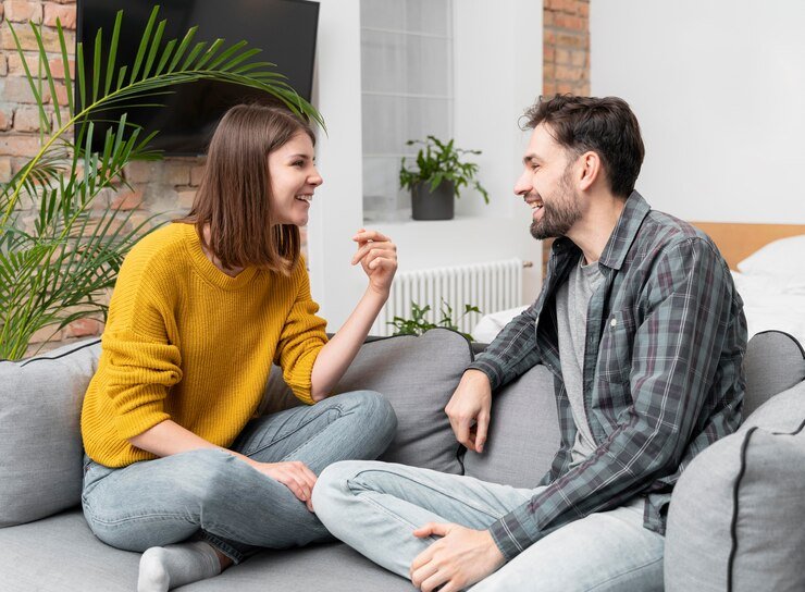 pareja-tiro-medio-riendo-sofa_23-2148861201.jpg
