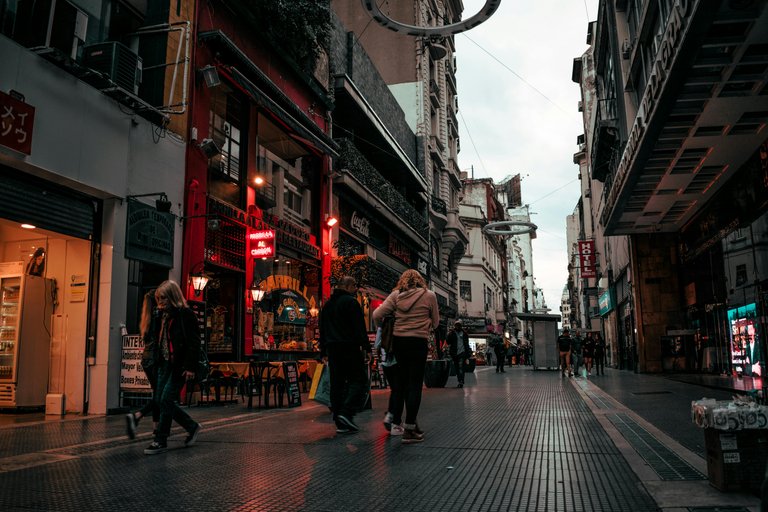 Free People Walking On Alley Near Buildings Stock Photo