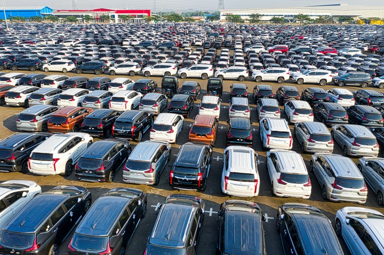 Free From above of rows with many modern new shiny automobiles of contemporary industry in daytime Stock Photo