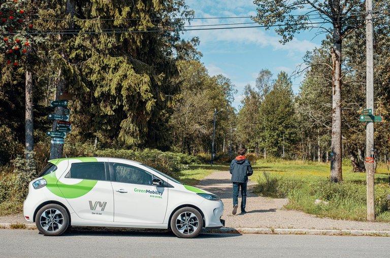 A car with Vy-logo, and forest landscape