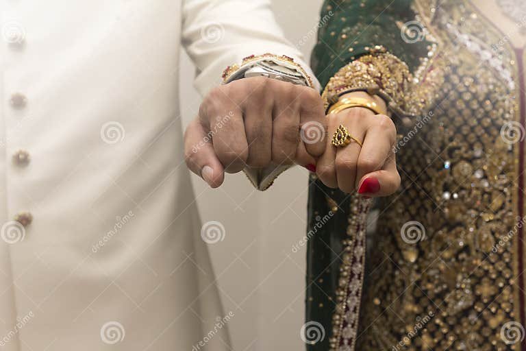 indian-bride-groom-holding-hands-53865074.jpg