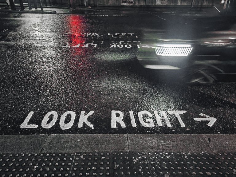 Why do people in the UK drive on the left-hand side while queuing on escalators on the right?