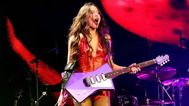 Olivia Rodrigo holding a purple guitar