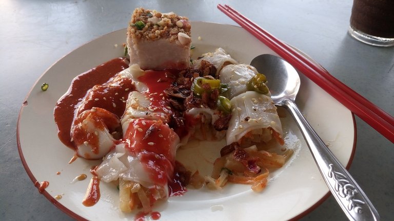 A portion of yam cake and chee cheong fun, rice noodle in translucent sheets, rolled with turnip filling, both eaten with chili sauce and black bean sauce