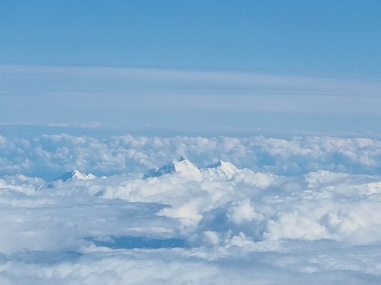 We were on a multi-city loop trip that went from Brisbane to Sydney, to Auckland and then Wellington, and we were just starting our descent into Queenstown when we saw this out the window of the plane. In case it’s not clear, what you’re looking at is the top of a snow-covered mountain poking out through a sea of clouds.