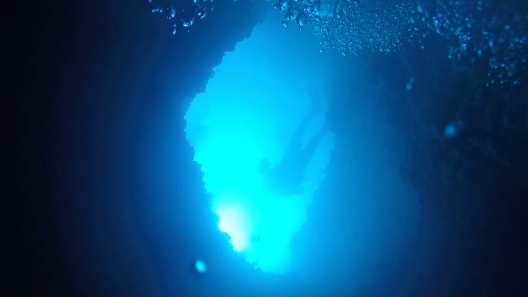 My dive buddy waiting for me at the exit of the siphon-shaped cave, at 22 meterts depth.