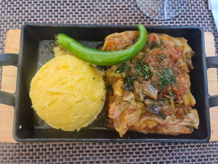 ”Sarmale Transilvane”: minced pork meat rolled into pickled cabbage leaves (similar to Korean ”kimchi”) topped with a kind of ratatouille and sided with a ball of polenta (cooked corn grits) and a fresh chili pepper (37 RON = 7.40 EUR) (1).