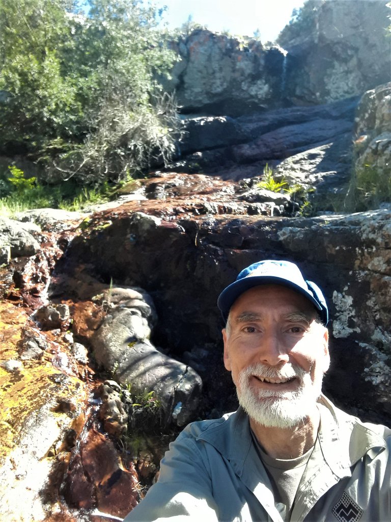 Portrait of your blogging travel guide at the waterfall