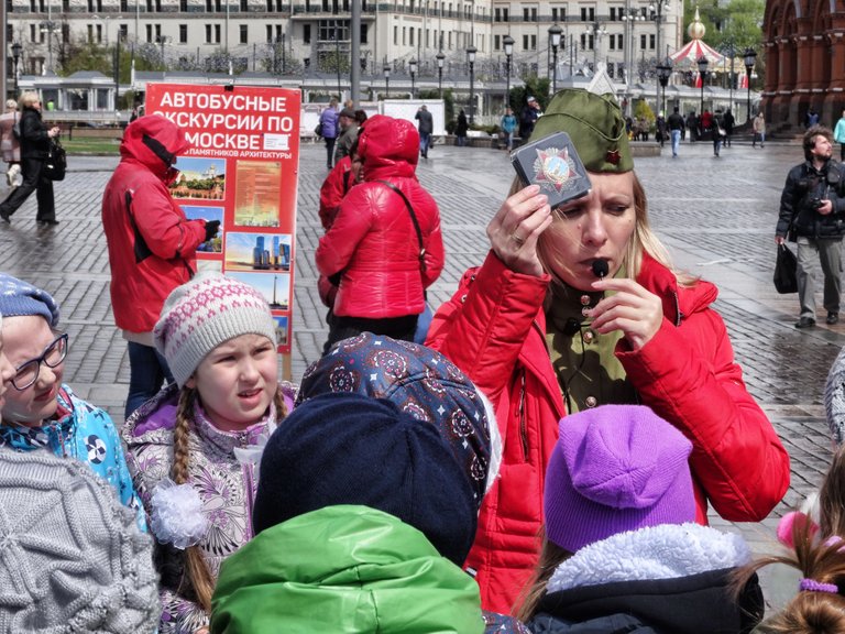 She is telling the kids something about the revolution and the WW2