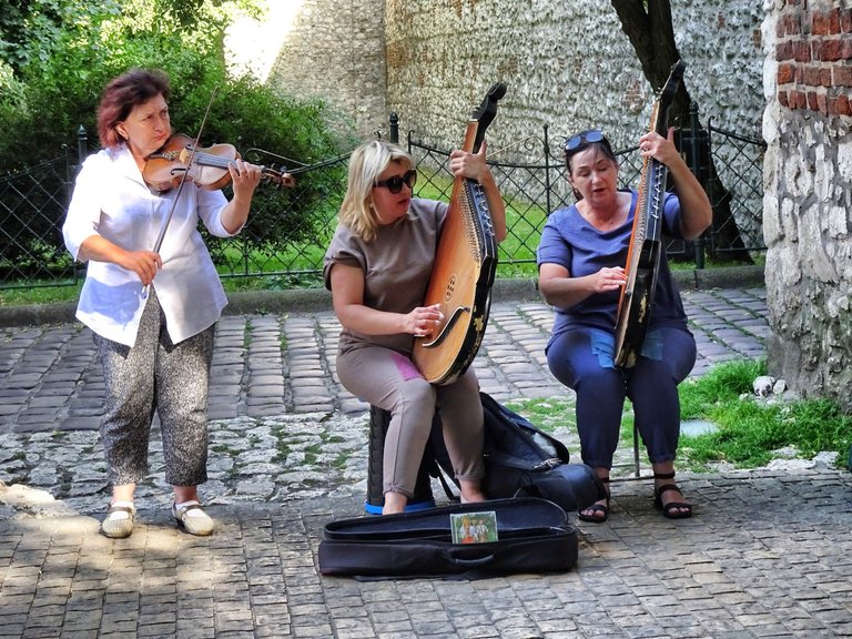 Three womad buskering with traditional polish music