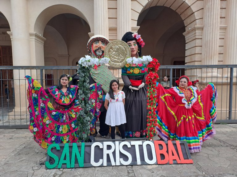 Post card photo taken in El Zocalo accompanied by 2 lovely dancers and giant puppets in the back