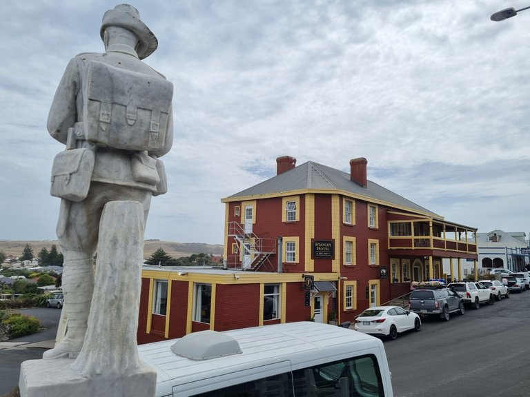 The back of an Anzac Statue and the pub.