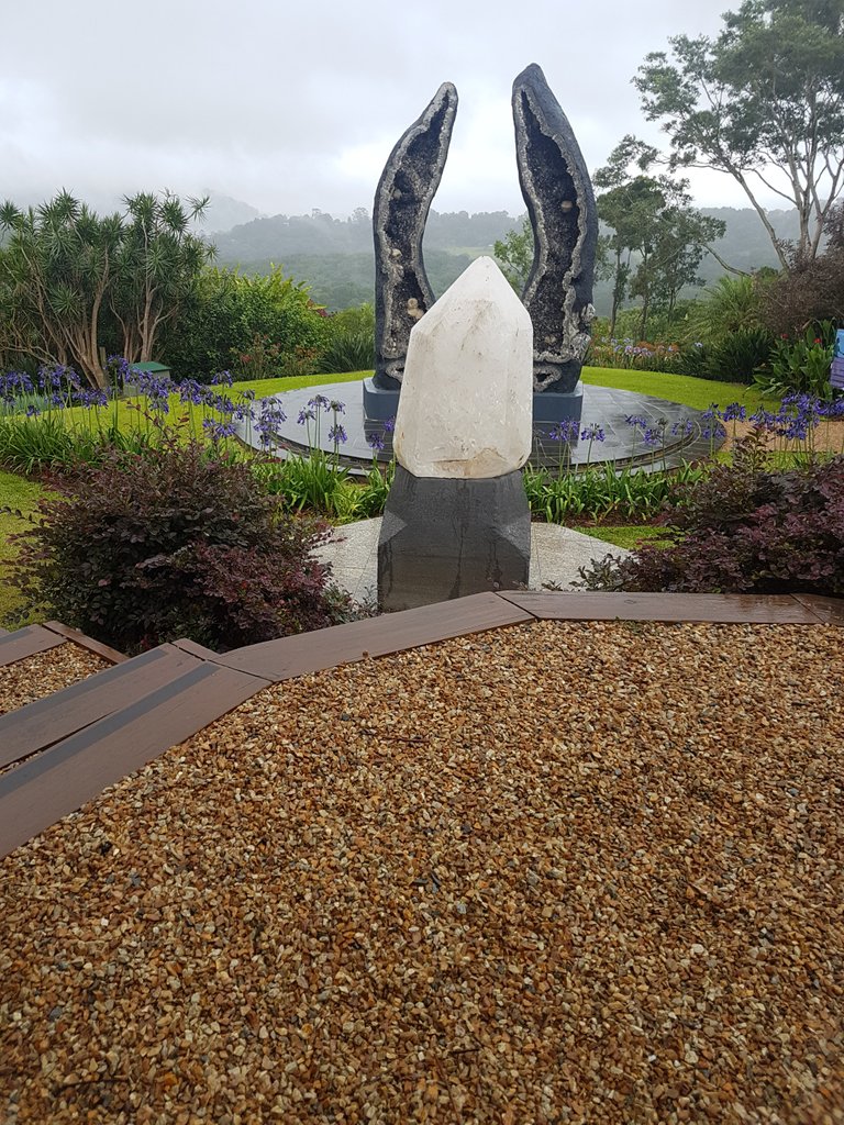 A large piece of clear quartz in front of the tallest geode pair in the world. ”The Crystal Guardians”