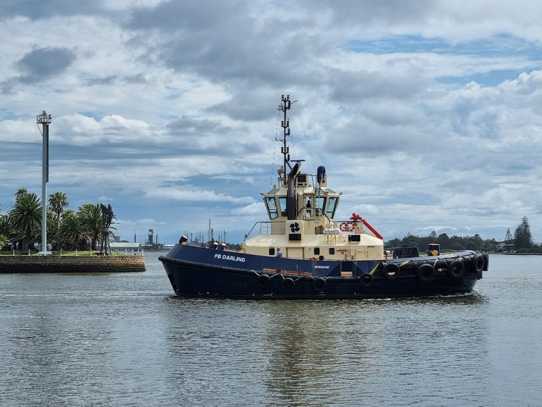 A tug boat going out and meet a ship