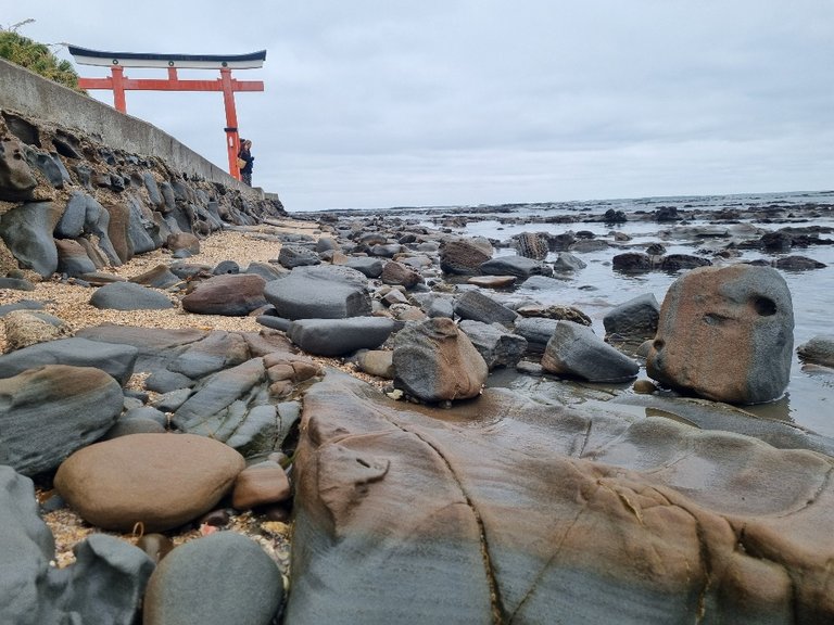A Torii Gate in the background (marks the entrance to the Shrine) and water-worn rocks in the foreground made it look even more beautiful.
