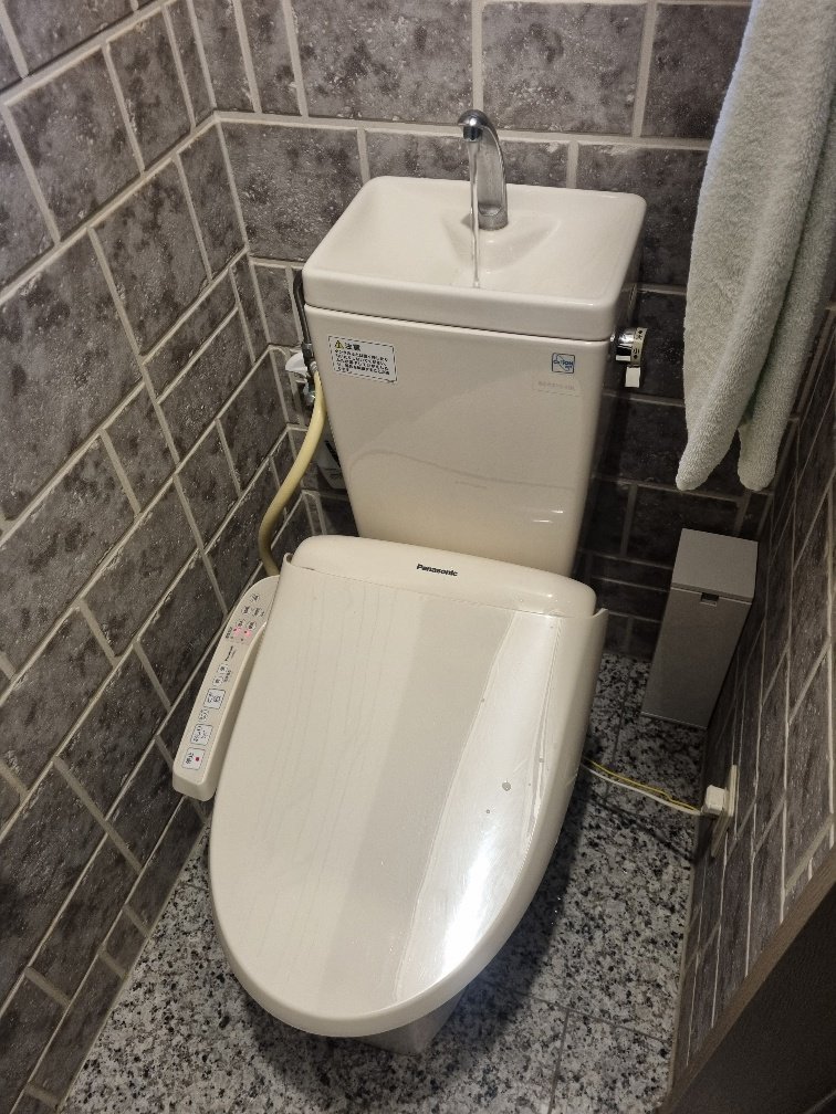 An automated electronic toilet with a hand wash basin on top which refilled the toilet cistern after use.