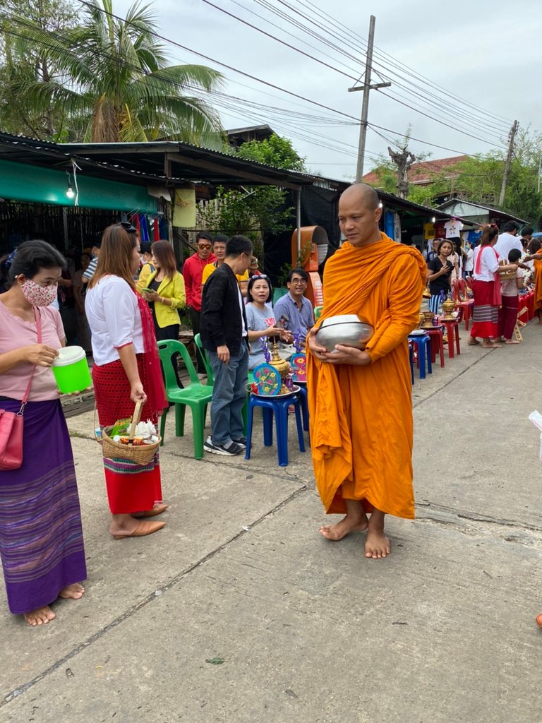 People are offering food to the monks