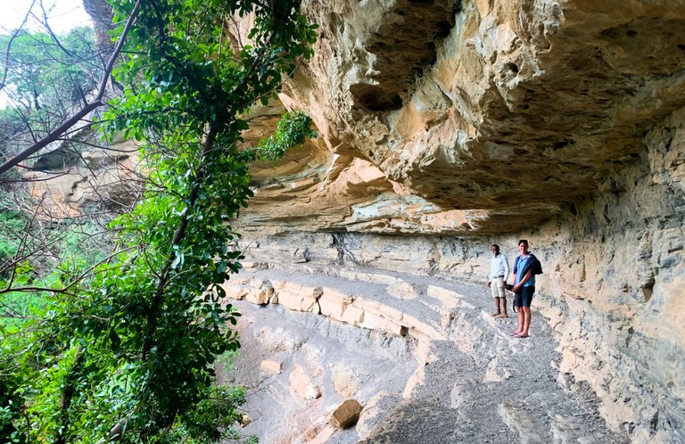 Dwarfed by the overhanging rock.